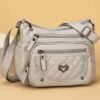 Sac à bandoulière tendance pour femme Un modèle uni et polyvalent, rehaussé d'un charmant détail en forme de cœur. Doté de multiples poches pratiques et d'une bandoulière facilement ajustable.