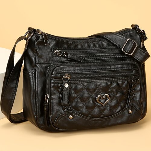 Sac à bandoulière tendance pour femme Un modèle uni et polyvalent, rehaussé d'un charmant détail en forme de cœur. Doté de multiples poches pratiques et d'une bandoulière facilement ajustable.