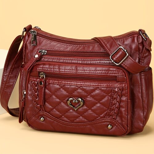 Sac à bandoulière tendance pour femme Un modèle uni et polyvalent, rehaussé d'un charmant détail en forme de cœur. Doté de multiples poches pratiques et d'une bandoulière facilement ajustable.