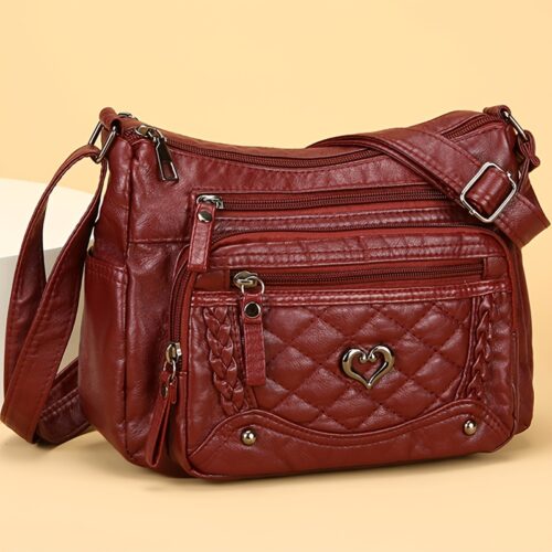 Sac à bandoulière tendance pour femme Un modèle uni et polyvalent, rehaussé d'un charmant détail en forme de cœur. Doté de multiples poches pratiques et d'une bandoulière facilement ajustable.