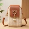 Le sac bohème indispensable des vacances ! Pochette téléphone en paille tressée, finitions à gland et nouveau rabat supérieur. Un look croisé ultra-décontracté.