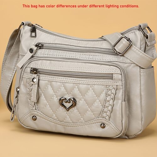 Sac à bandoulière tendance pour femme Un modèle uni et polyvalent, rehaussé d'un charmant détail en forme de cœur. Doté de multiples poches pratiques et d'une bandoulière facilement ajustable.