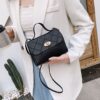 Le sac fourre-tout carré, noir et exclusif. Une silhouette géométrique épurée rehaussée d'un détail de boucle métallique.