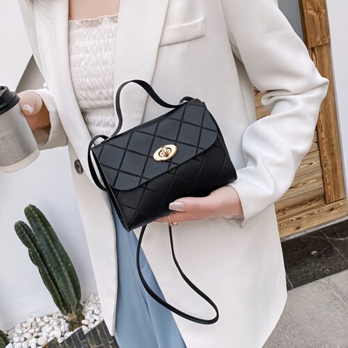 Le sac fourre-tout carré, noir et exclusif. Une silhouette géométrique épurée rehaussée d'un détail de boucle métallique.