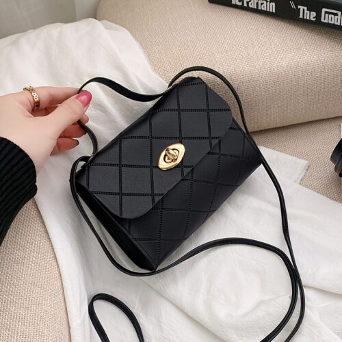 Le sac fourre-tout carré, noir et exclusif. Une silhouette géométrique épurée rehaussée d'un détail de boucle métallique.